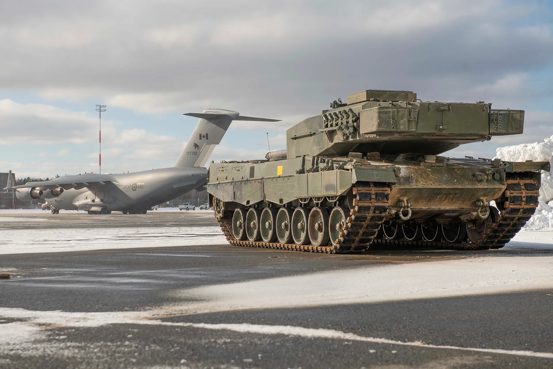 Kampfpanzer bereit zum Verladen und Weitertransport durch die auf dem Rollfeld wartende Boeing C-17 Globemaster der Royal Canadian Air Force.