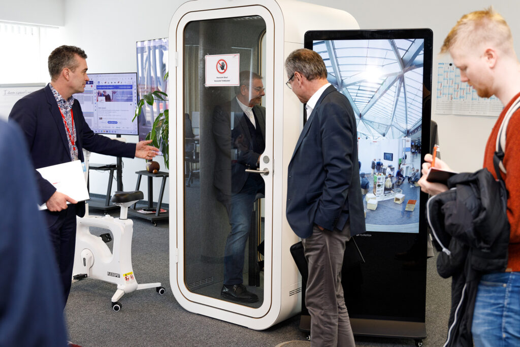 Präsentation und Test einer der neu installierten, schallgeschützten Telefonboxen für ungestörte oder sicherheitssensible Gespräche am BWI-Standort Bonn-Auermühle.