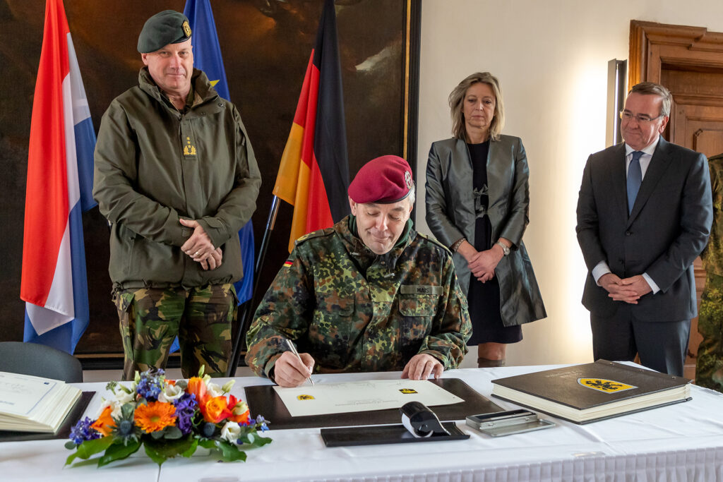 Generalleutnant Alfons Mais, Inspekteur des Deutschen Heeres (Mitte) bei der Unterzeichnung der Bücher der Stadt im Rahmen der feierlichen Unterstellung. Links von ihm: Generalleutnant Martin Wijnen, niederländischer Kommandeur der Landstreitkräfte. Rechts von ihm die Verteidigungsministerin Kajsa Ollongren und der deutsche Verteidigungsminister Boris Pistorius.