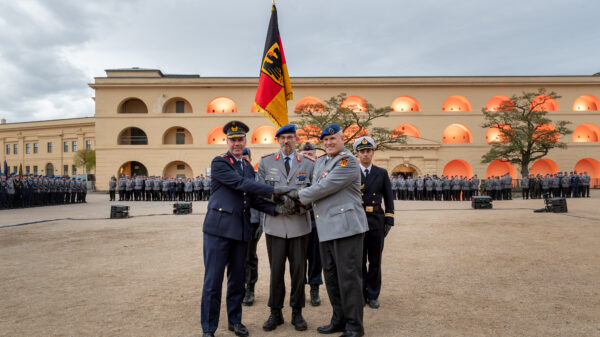 Indienststellung: Das Kommando Gesundheitsversorgung der Bundeswehr wurde am 22. September 2025 offiziell in den Dienst gestellt. Besiegelung durch Händedruck Befehlshaber Unterstützungskommando, Generalleutnant Gerald Funke, Kommandeur Kommando Gesundheitsversorgung, Generalstabsarzt Dr. Johannes Backus, und Befehlshaber Zentraler Sanitätsdienst der Bundeswehr, Generaloberstabsarzt Dr. Ralf Hoffmann, vor der Truppenfahne.