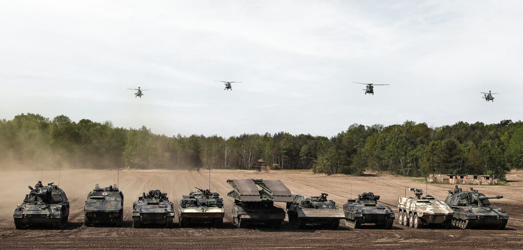 Chancengleichheit: Fahrzeuge und Hubschrauber während einer Leistungsschau der Landstreitkräfte im Rahmen der Besuchs der ehemaligen Bundeskanzlerin bei der multinationalen Schnellen NATO-Eingreiftruppe, die Very High Readiness Joint Task Force (VJTF), auf dem Truppenübungsplatz in Munster. Foto: Bundeswehr / Sebastian Wilke