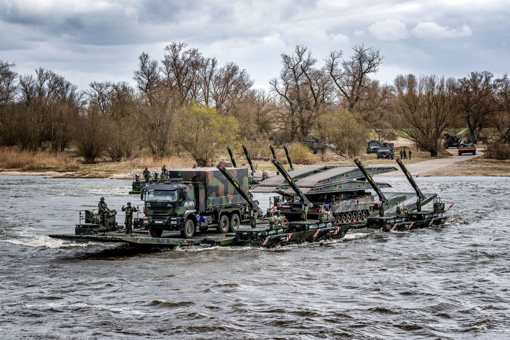 Brückenlegepanzer LEGUAN und ein Lkw überqueren auf einer Fähre aus Schwimmschnellbrücken AMPHIBIE M3 des Deutsch/Britischen Pionierbrückenbataillons 130 die Elbe in Storkau. Foto: Bundeswehr / Marco Dorow