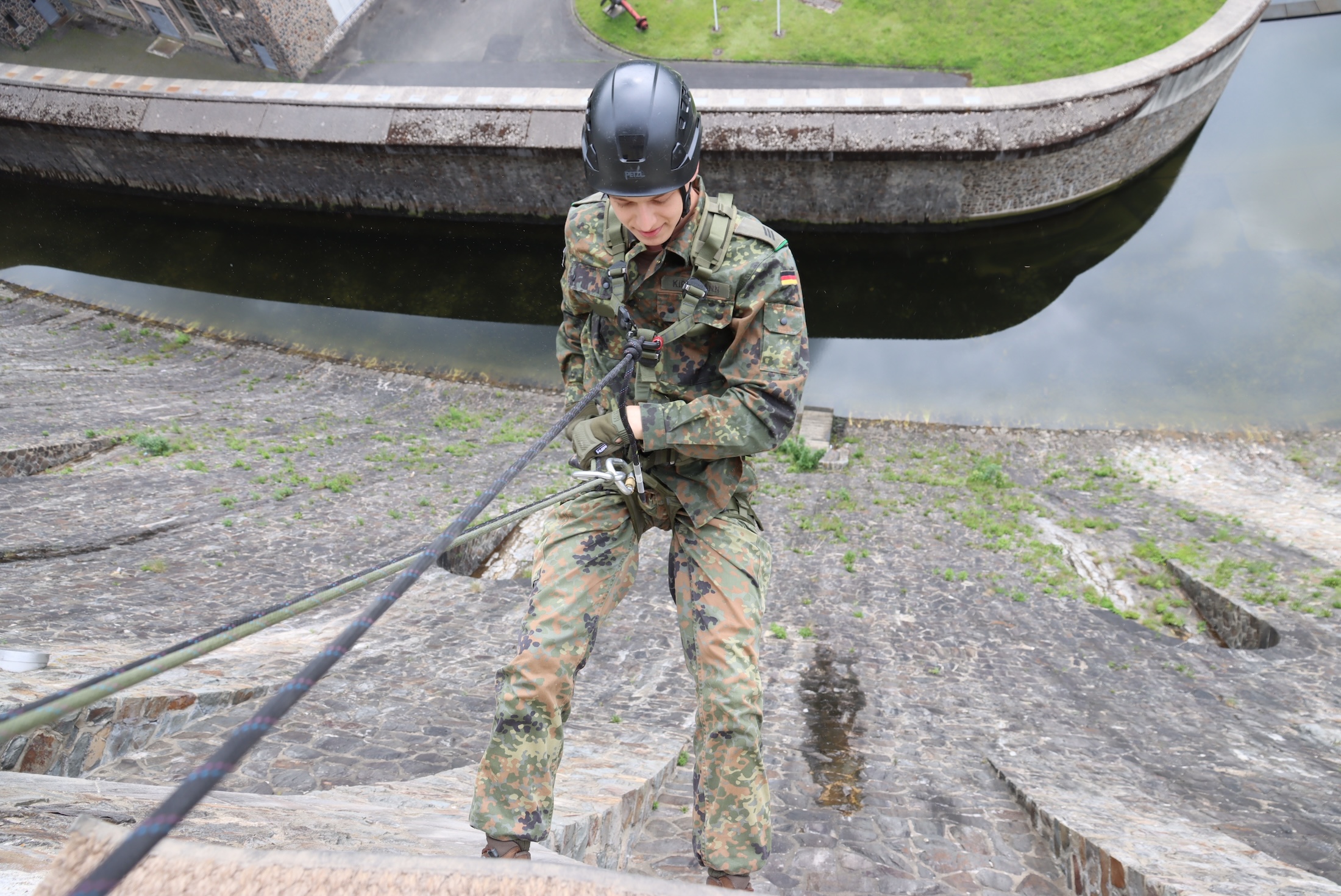 Luftlande-Soldat der Division Schnelle Kräfte am Seil rückwärts die Staumauer hinunter.