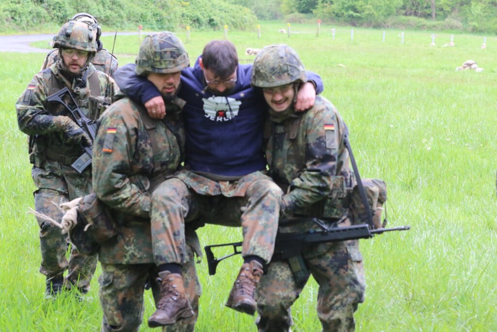 Noch im Gelände durchsuchten die Soldaten eine zivile Person nach Waffen, versorgten lebensgefährliche Verletzungen. Dann folgt der Transport in den sicheren Bereich.