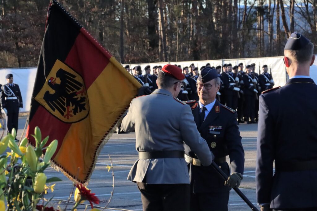 Der scheidende Amtschef hat die Verantwortung über das Planungsamt symbolisch mit der Truppenfahne an den Generalinspekteur zurückgegeben.