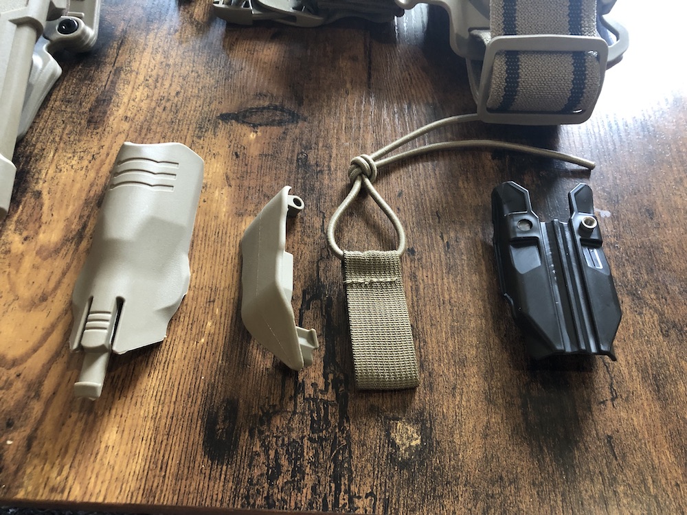 Extra für das Kit entwickelt wurden unter anderem eine Lichtblende zum Verhindern von Licht-IEDs, die Sicherung für den Sprungeinsatz sowie ein Adapter für das Reflexvisier (v.l.n.r.).