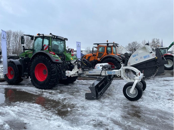militärische Traktoren: FENDT 700 Traktor mit Stehr Anbaugrader SUG 35-T. Dabei handelt es sich um ein System mit hoher Arbeitsgeschwindigkeit zur Instandhaltung von z.B. Wegen zur Übergangsstelle. So lassen sich sämtliche Wegebauprofile schnell und einfach herstellen. Im Hintergrund FENDT 900 mit STEHR Grabenfräse.