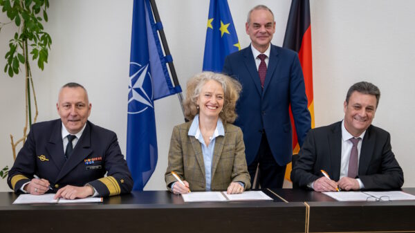 Rüstungsbeschaffung der Zukunft: Staatssekretär Zimmer (stehend), Vizeadmiral Stawitzki (l.), Prof. Kern (m.) und Vizepräsident des BAAINBw Herzog (r.) bei der Unterzeichnung