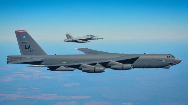 B-52 Bomber wird von Kampfjet begleitet.