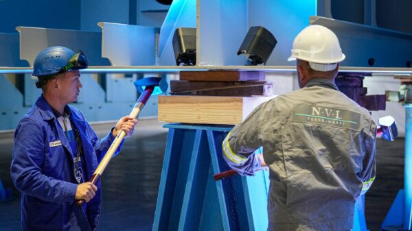 Feierlicher Moment: Schiffsbauer der Neptun-Werft setzen ihre Vorschlaghämmer ein, um eine Holztafel mit einer Münze am Kiel des neuen Marinetankers anzubringen. Diese Schiffsbautradition soll dem Schiff und seiner Besatzung Glück bringen.