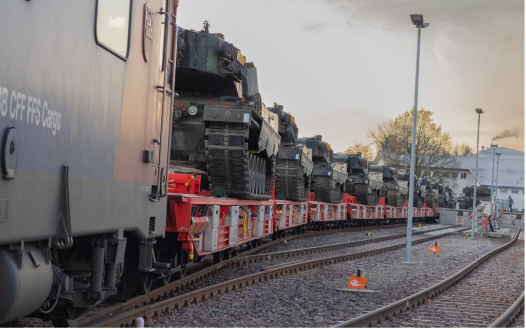 zahlreiche Kampfpanzer vom Typ Leopard auf einem Zug verladen.